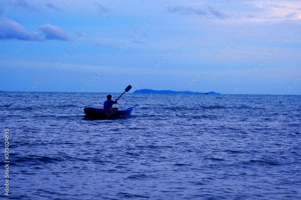 A man rolls boat on blue sea