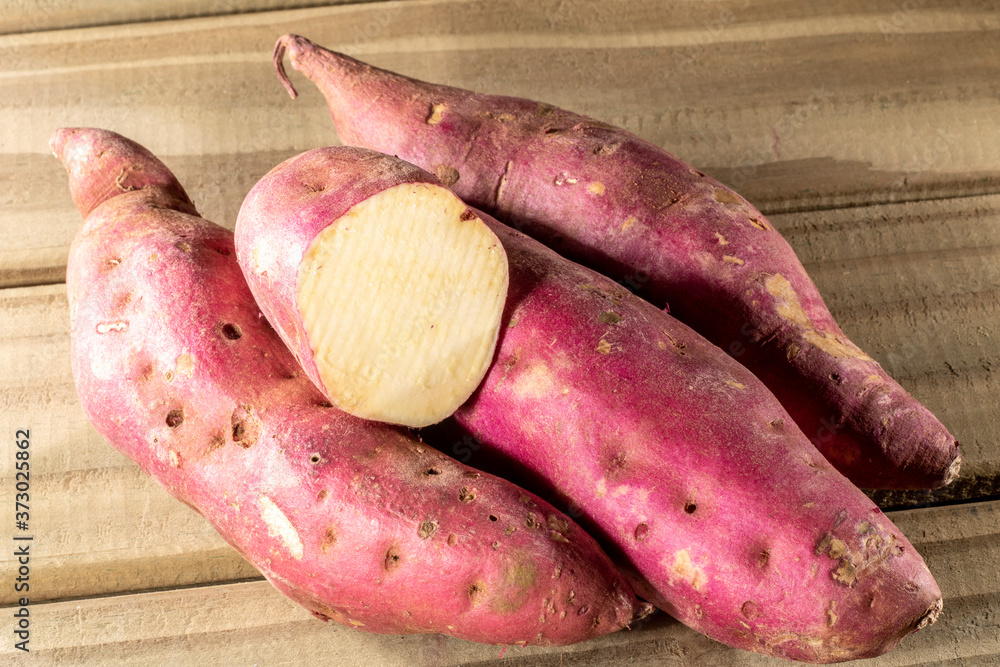 Red sweet potato pile on wooden background in Brazil Red sweet potato pile on wooden background in Brazil