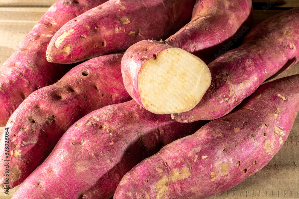 Red sweet potato pile on wooden background in Brazil Red sweet potato pile on wooden background in Brazil