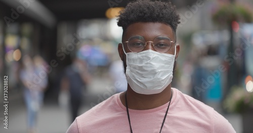 Young black man in city wearing a mask 