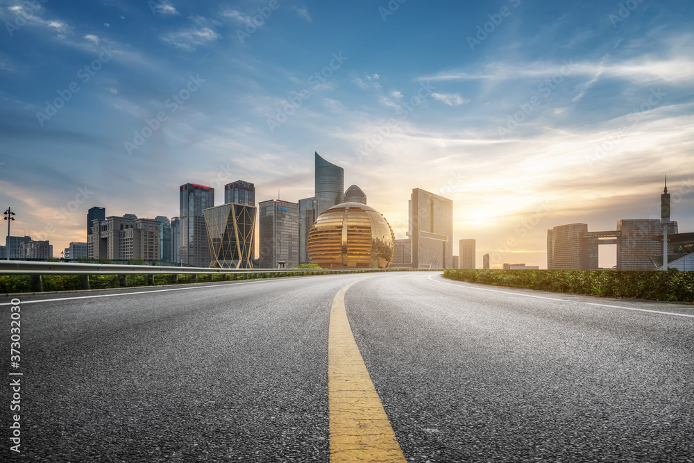 Empty asphalt road along modern commercial buildings in China, s cities Empty asphalt road along modern commercial buildings in China, s cities