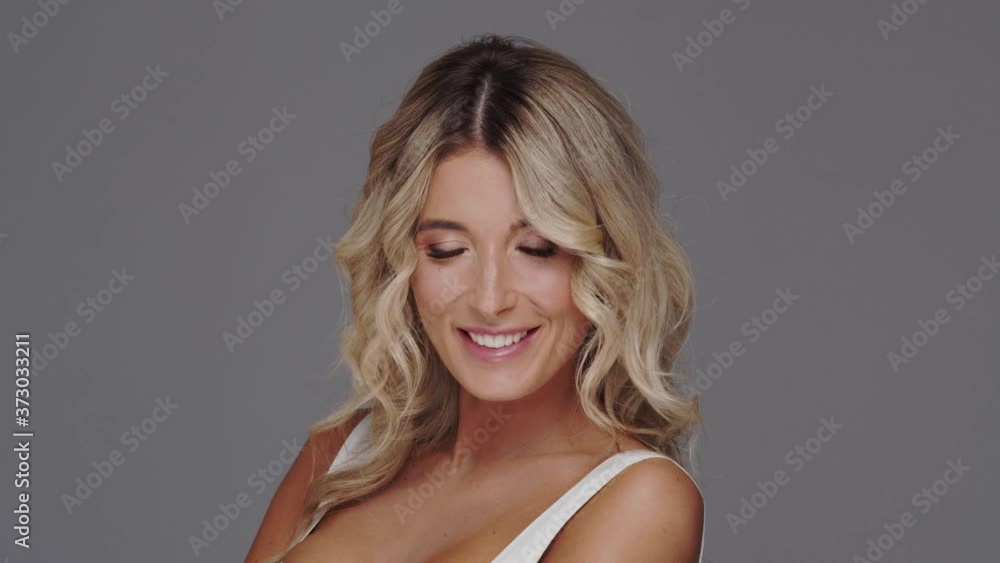 Studio portrait of young and beautiful blond woman over grey background. Studio portrait of young and beautiful blond woman over grey background.