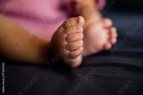 Baby feet on the bed as a background, closeup of infant toes, maternity and babyhood concept