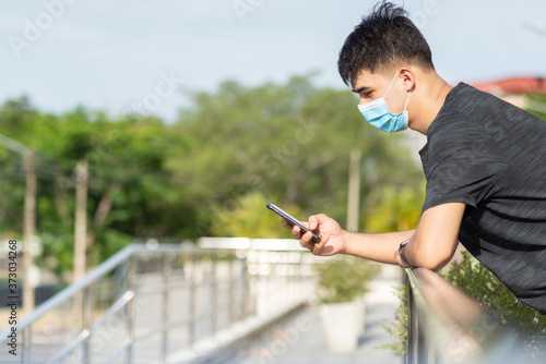 Portrait of young Asian man with face mask to protect and prevent from the spread of viruses in the city during COVID-19 pandemic