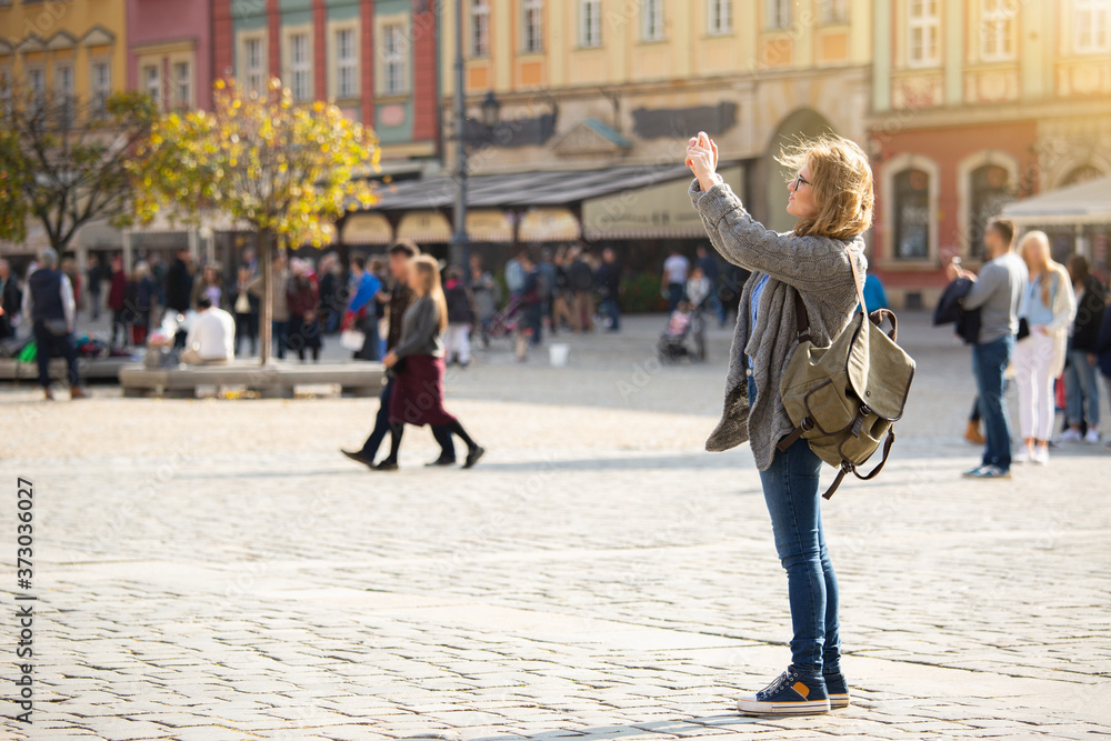 Woman traveler photographing landmark on smartphone camera