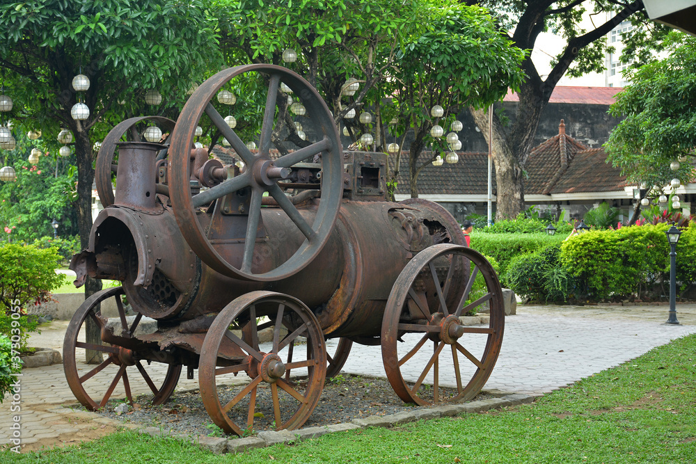 Baluarte De San Diego rusty locomotive train and parts display at Intramuros walled city in Manila, Philippines