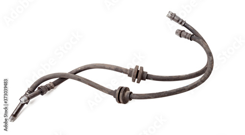 Pair of old brake hoses on white background in photo studio - a high-pressure hose with fluid and metal nozzles for replacement during repairs or for catalog of spare parts for sale on auto parsing.