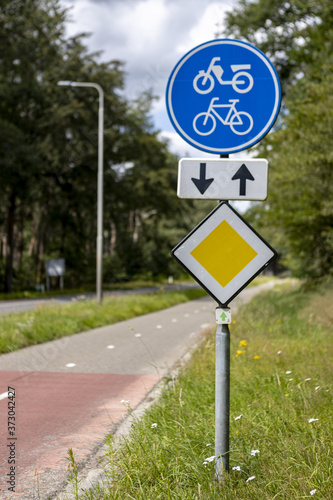 HOGE HEXEL, NETHERLANDS - Jul 30, 2020: Traffic signs on the side of a bike path and priority road photo