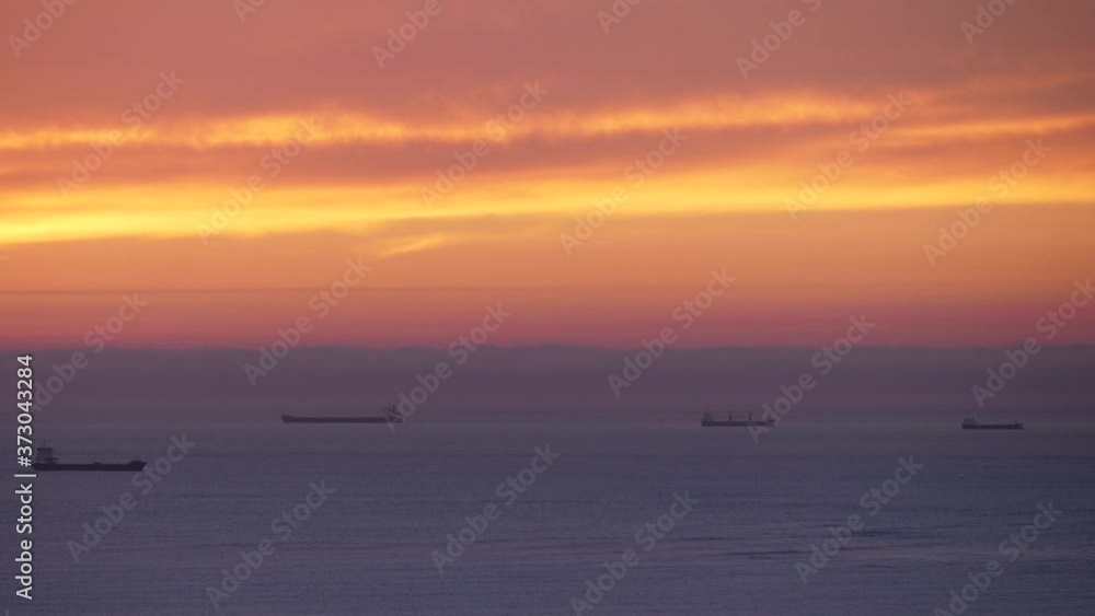 beautiful sunset sky over the sea with cargo ship on the horizon beautiful sunset sky over the sea with cargo ship on the horizon
