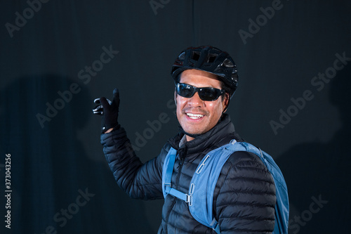 portrait of cyclist with helmet and glasses on dark background