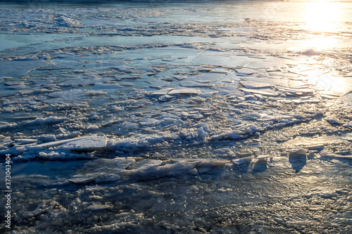 Ice texture on the river of the sunset sun. Selective focus.