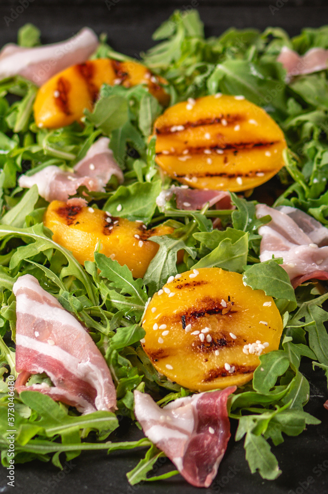 Delicious salad with grilled peaches and prosciutto