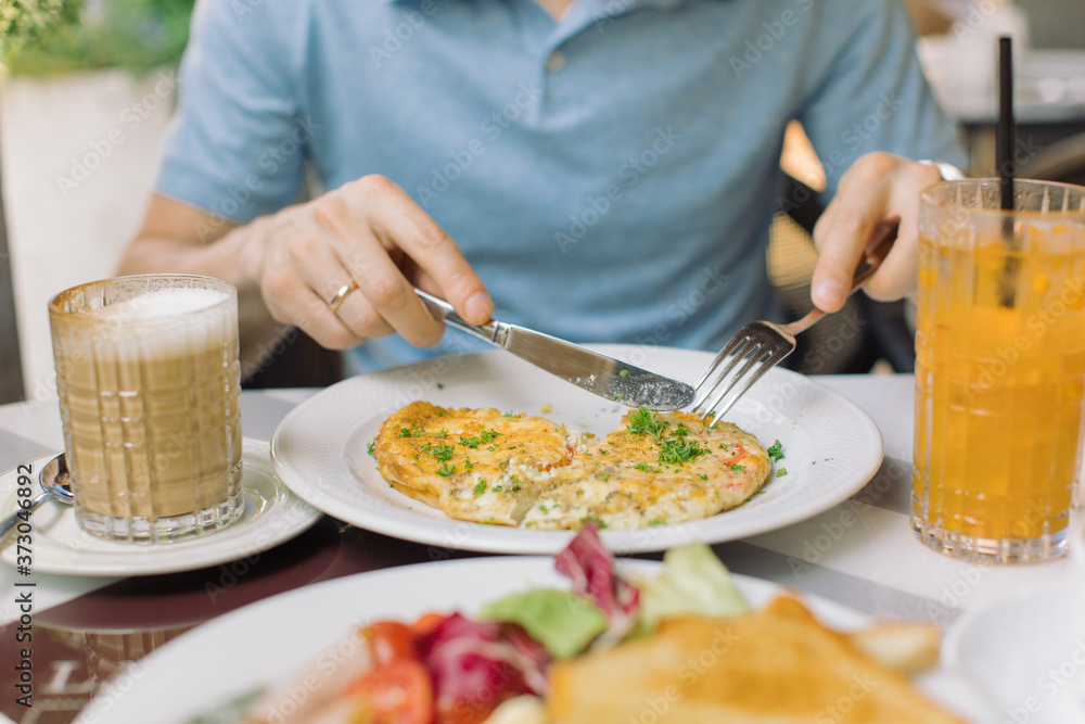 Man eating omelet with bacon and vegetables. Breakfast concept. Man eating omelet with bacon and vegetables. Breakfast concept.