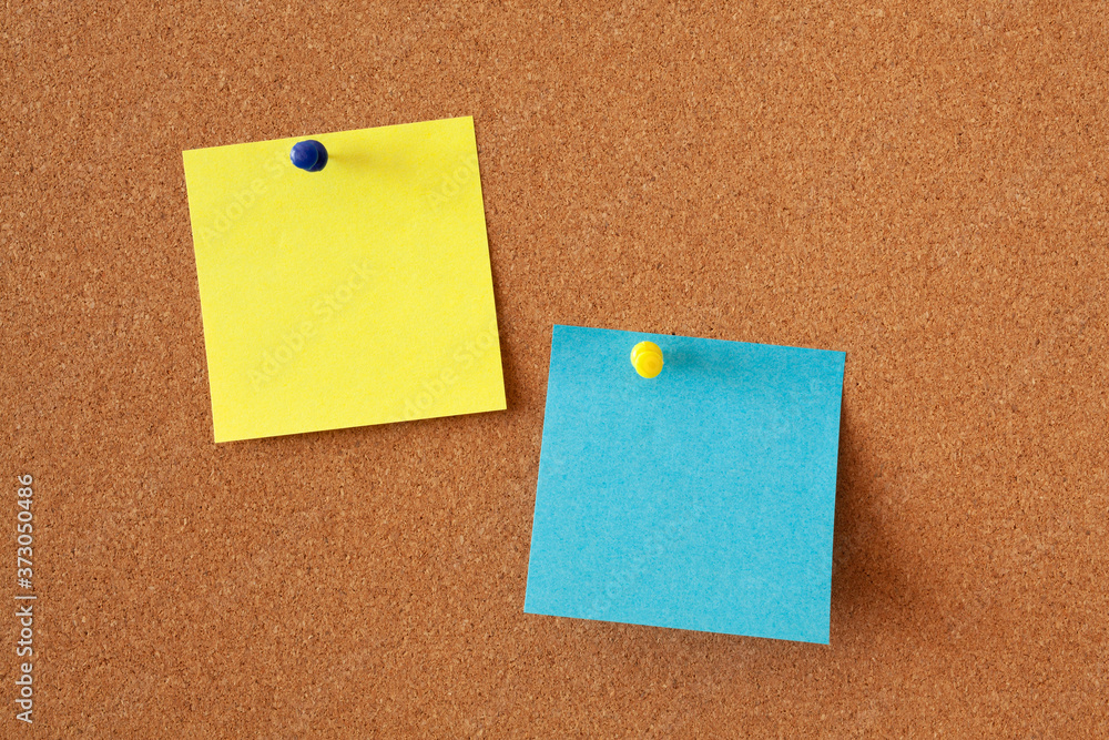Yellow and blue sheets for notes on a corkboard. Office or business background. Yellow and blue sheets for notes on a corkboard. Office or business background.