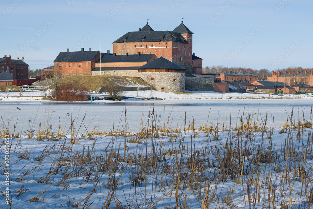 View of the ancient fortress of the Hameenlinna city from the shores of Vanajavesi lake on a March day. Finland