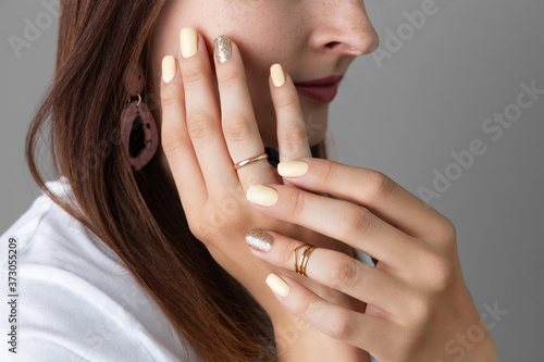 Woman with yellow shiny nail design. Beauty salon template