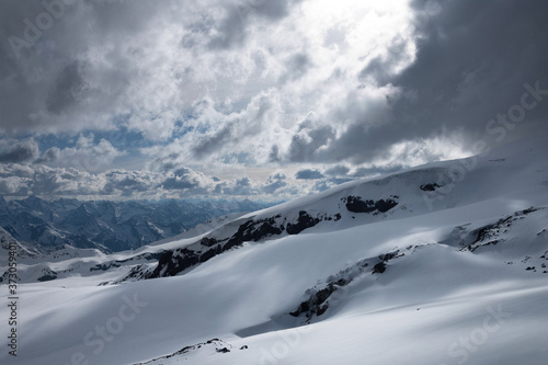 Evening high mountain scenery snow-covered rocky steep mountains of the main mountain range of the northern Caucasus