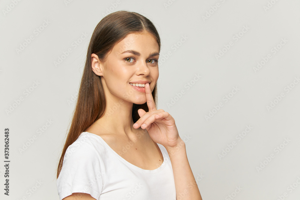 Brunette in White T-shirt Holds Finger Near Secret Model Face Smile Copy Space Brunette in White T-shirt Holds Finger Near Secret Model Face Smile Copy Space