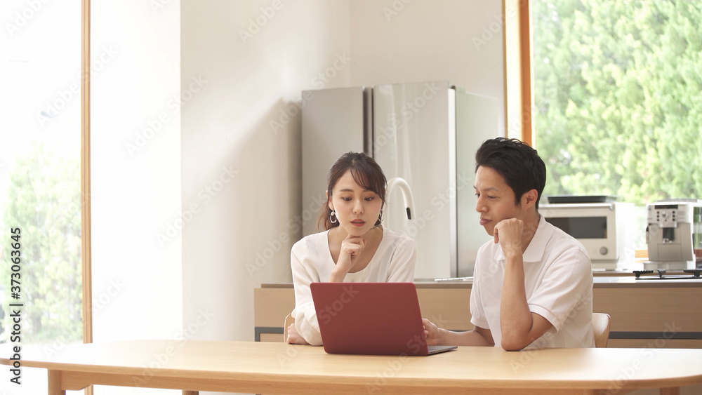 ノートパソコンを使う新婚夫婦	