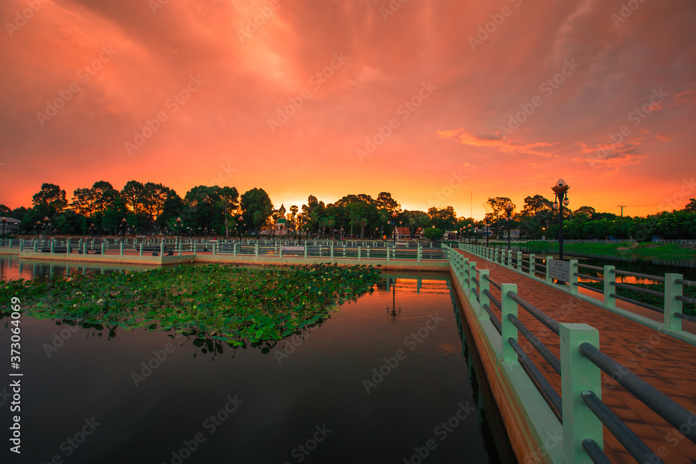 The blurry abstract background of the morning sky by the reservoir and there is a walkway to watch nature for exercise or rest while traveling.