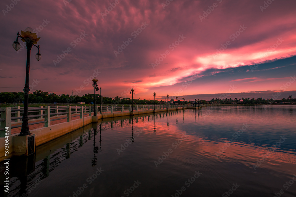 Obraz premium The blurry abstract background of the morning sky by the reservoir and there is a walkway to watch nature for exercise or rest while traveling.