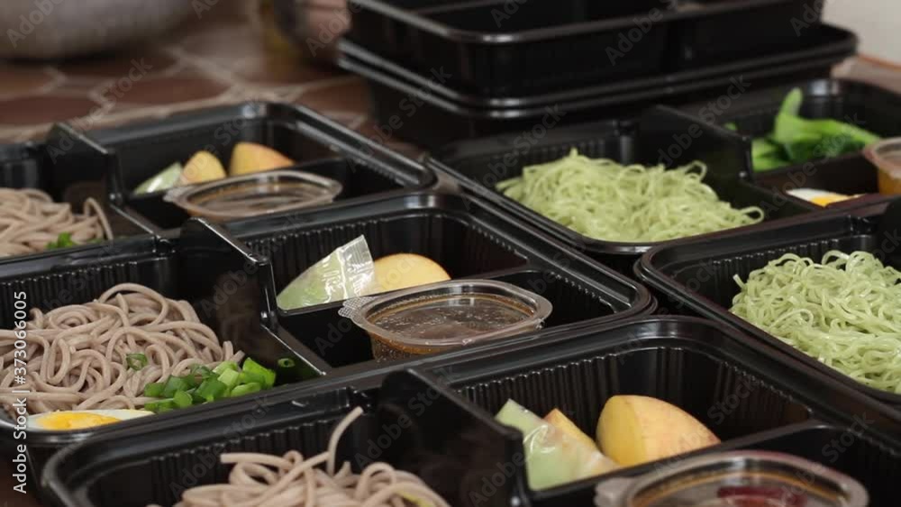 Hand of chef with surgical gloves prepare food box to delivery after get many order from customer thought online shop, Online food business concept.