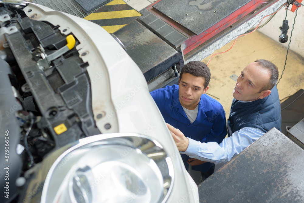 mechanics checking the technical state underneath a car mechanics checking the technical state underneath a car