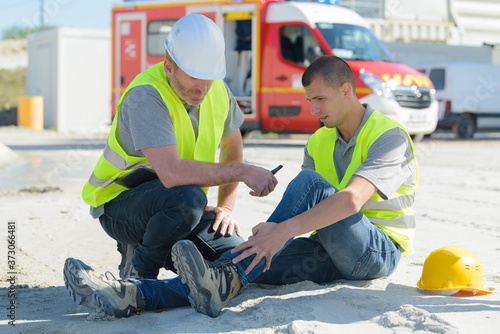 Canvas Print young construction worker on site with injured ankle