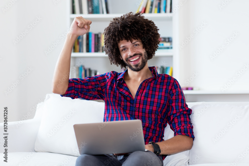 Cheering latin american hipster man in quarantine at computer Cheering latin american hipster man in quarantine at computer
