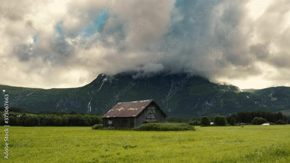 Scenic View Of A Deserted Wooden Barnhouse On The Green Meadows In Hemsedal With Gray Clouds Soaring Above - timelapse Scenic View Of A Deserted Wooden Barnhouse On The Green Meadows In Hemsedal With Gray Clouds Soaring Above - timelapse