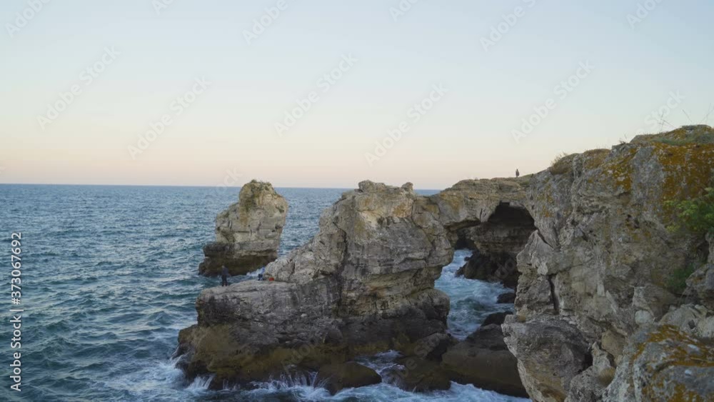 Aerial view of tourists walking on rock arc in the sea near Tyulenovo in sunny summer day Aerial view of tourists walking on rock arc in the sea near Tyulenovo in sunny summer day