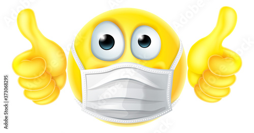 An emoticon emoji cartoon face icon wearing PPE medical mask and giving thumbs up