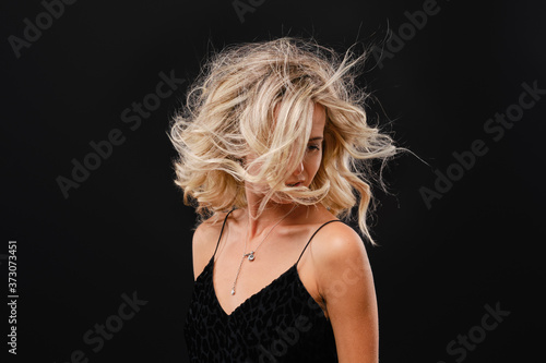 Low key photo of young happy woman with flowing hair