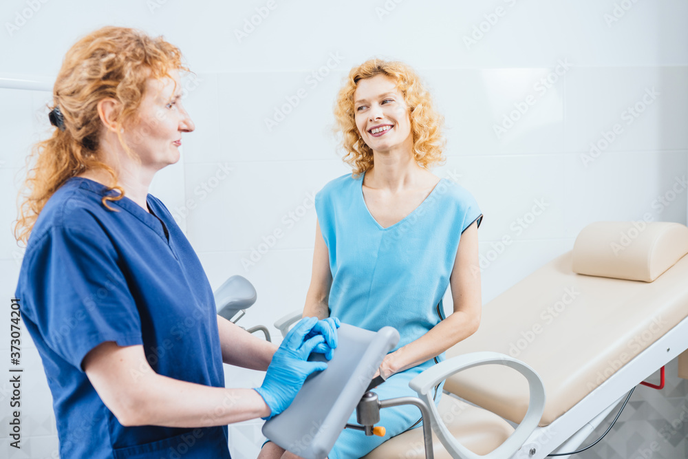 Middle age woman with gynecologist in cabinet. Female doctor after examines talking with female patient in gynecology chair. Disease prevention, timely inspection concept. Middle age woman with gynecologist in cabinet. Female doctor after examines talking with female patient in gynecology chair. Disease prevention, timely inspection concept.