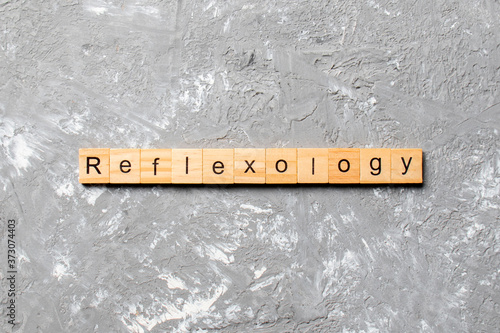 reflexology word written on wood block. reflexology text on cement table for your desing, concept