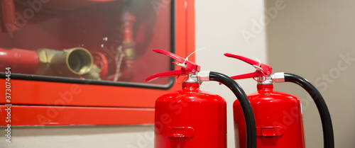 Red fire extinguishers tank and fire hose cabinet in the building concepts of emergency safety for fire prevention rescue and fire services concetps. photo