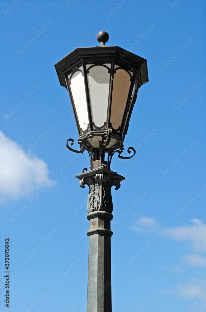 Isolated Ornate Black Iron Lantern on Street Light against Blue Sky  