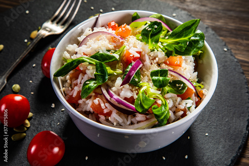 White rice and vegetables on wooden table