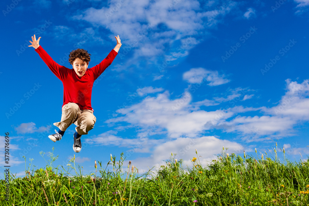 Boy jumping, running against blue sky
Boy jumping, running against blue sky