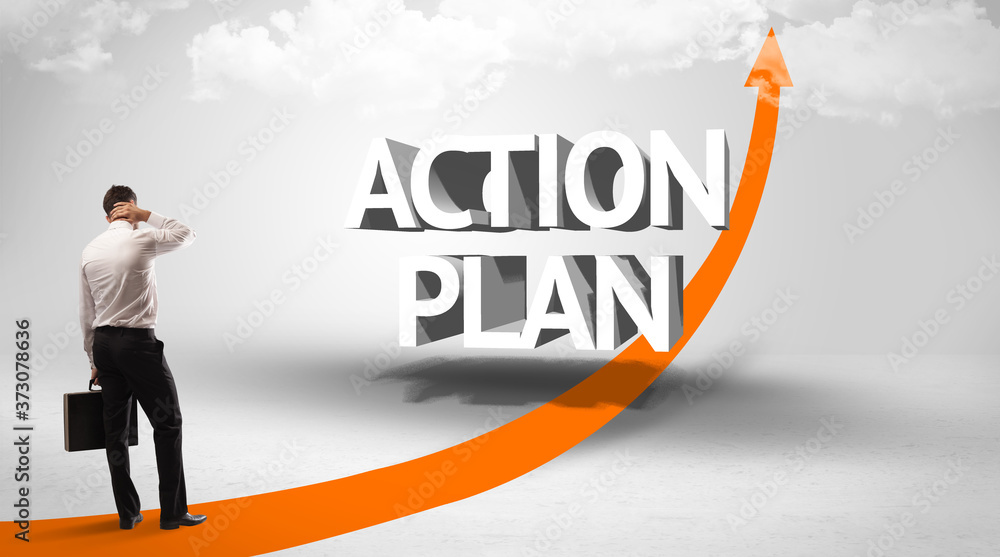Rear view of a businessman standing in front of ACTION PLAN inscription, successful business concept Rear view of a businessman standing in front of ACTION PLAN inscription, successful business concept