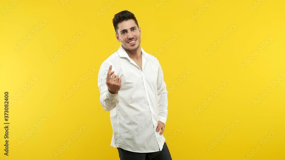 Young handsome man inviting to come, confident and smiling making a gesture with hand, being positive and friendly Young handsome man inviting to come, confident and smiling making a gesture with hand, being positive and friendly