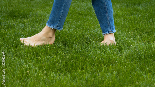 Woman stepping on mown lawn on backyard 
