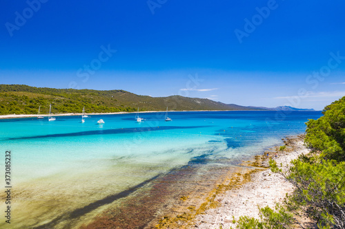 Fototapeta Naklejka Na Ścianę i Meble -  Amazing coastline in Croatia. Turquoise lagoon on Sakarun beach on Dugi Otok island, yachts and sailboats anchored in blue sea. Adriatic paradise. Drone aerial.