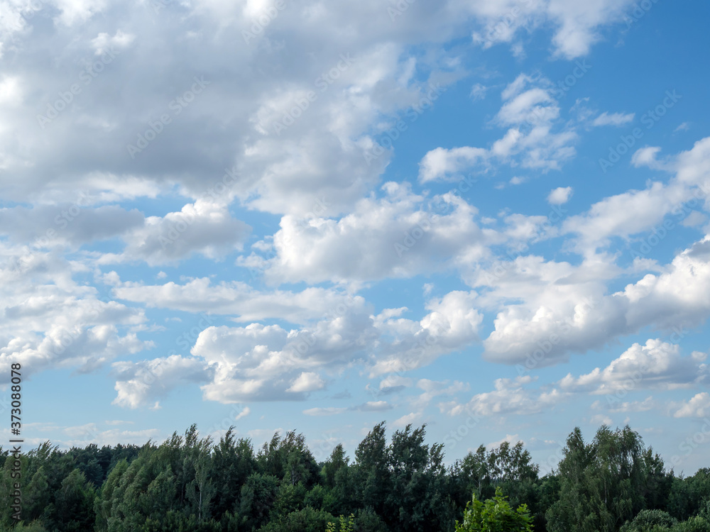 White clouds on a blue sky lit by the sun. White clouds on a blue sky lit by the sun.