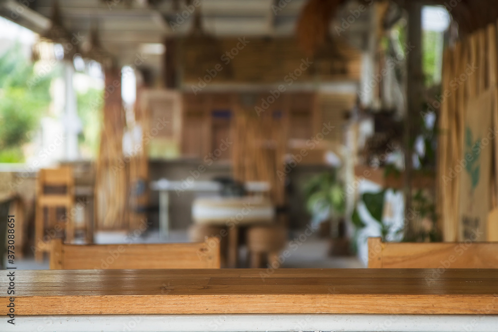 Empty wood table top and blurred bokeh restaurant, cafe and coffee shop interior background