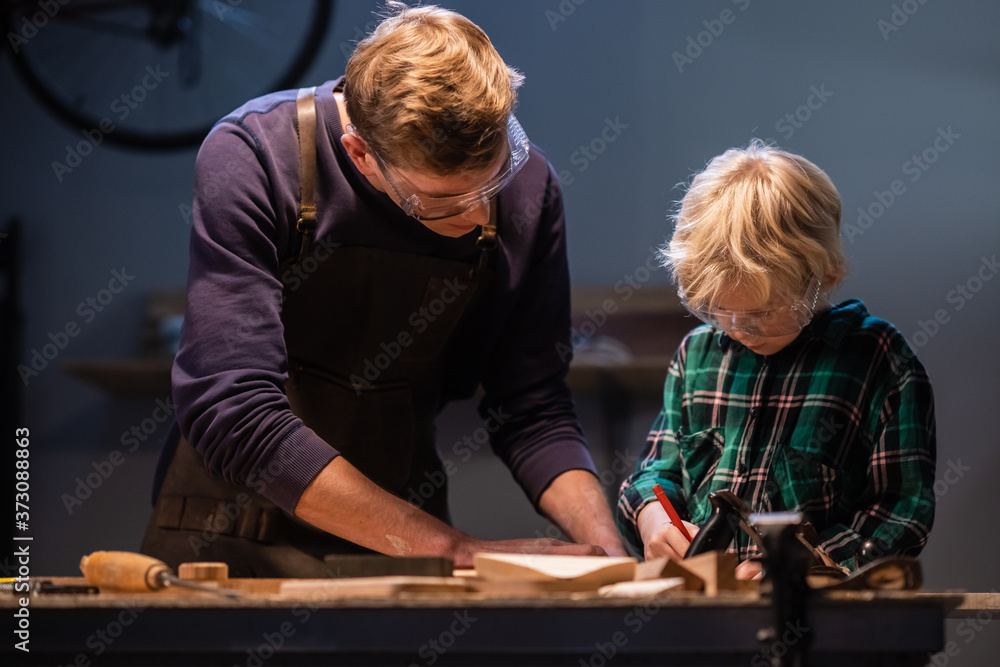 brothers prepare a gift made of wood for their mother in the garage. brothers prepare a gift made of wood for their mother in the garage.