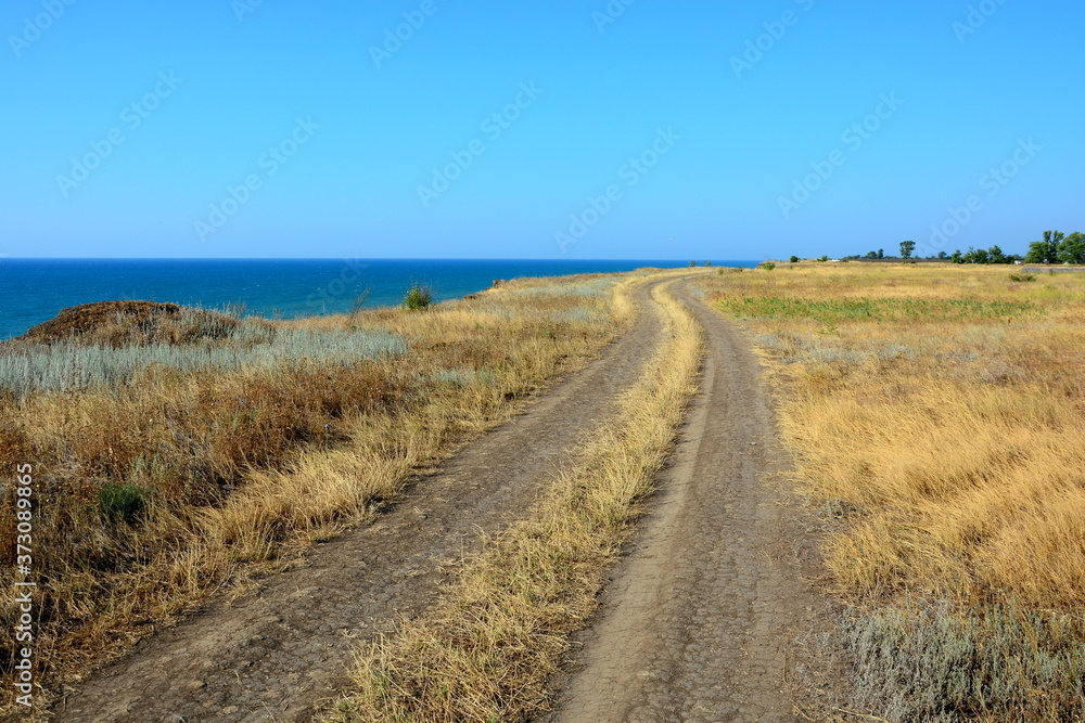 Country field road ruts along the sea.