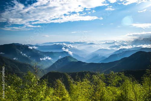 The panoramic layers of the Himalayan mountains of Sikkim, India are covered with clouds and fog.