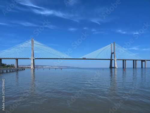 Walking the footpath Passeio do Tejo along Tagus river in Lisbon at the Expo park - Vasco da Gama bridge