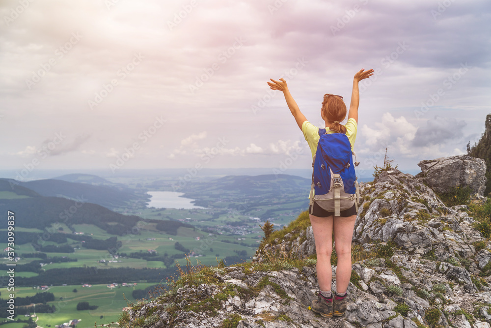 Adventure in the mountains. Young tourist girl on the top of a rocky mountain in Austria Adventure in the mountains. Young tourist girl on the top of a rocky mountain in Austria